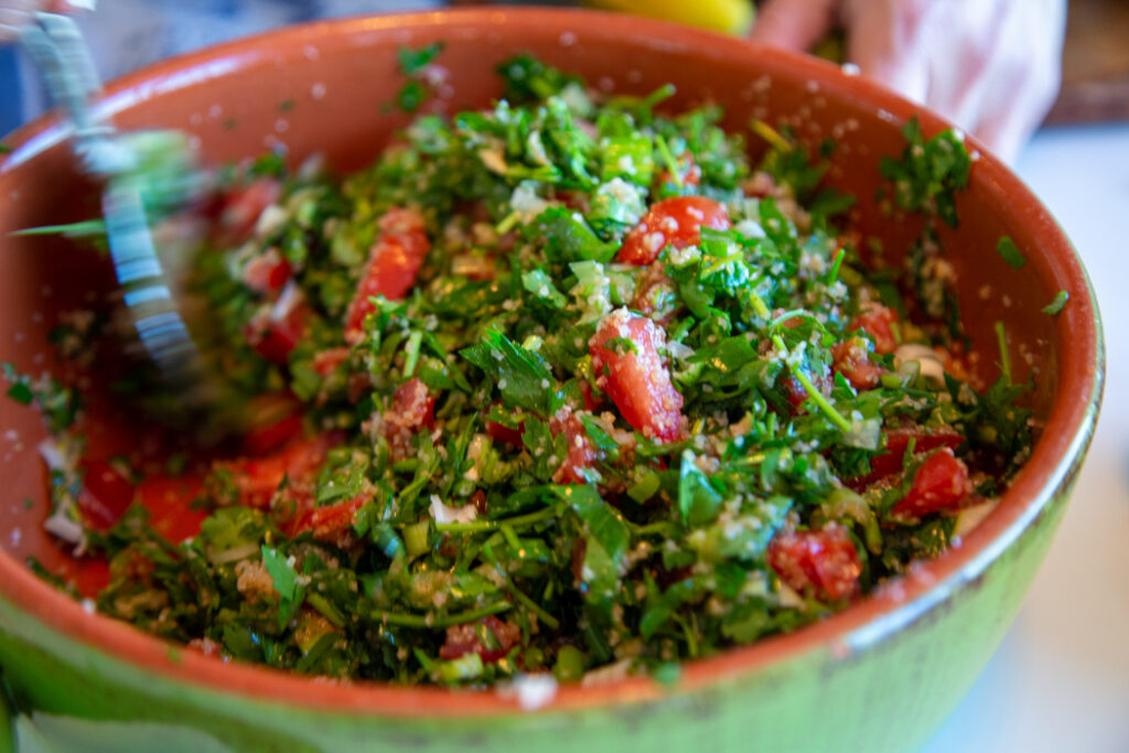 A bowl of salad with tomatoes and parsley.