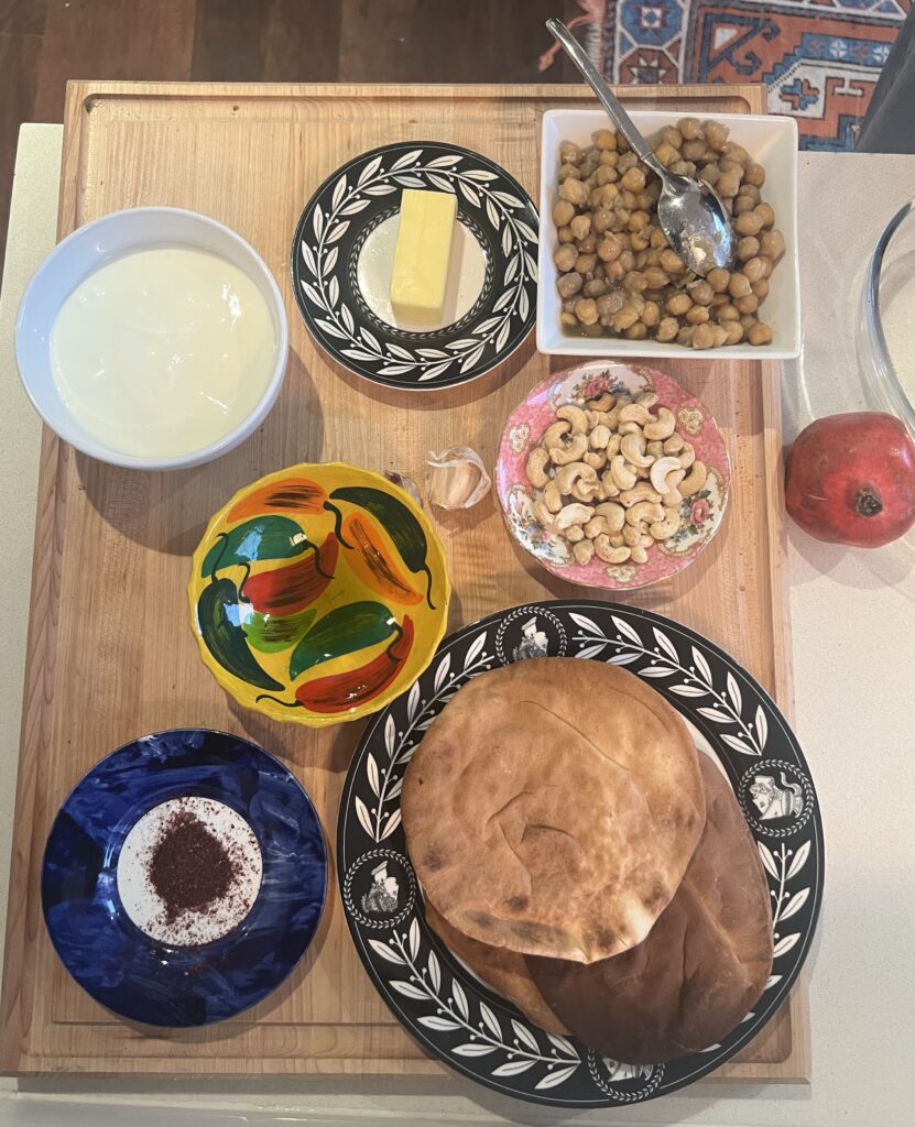 A wooden table topped with bowls of food.