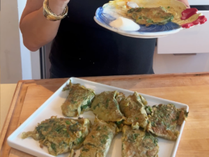 A person holding a plate of food on top of a table.