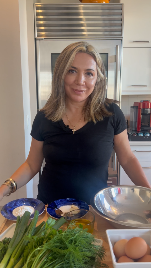 A woman holding a bowl of food in front of two bowls.