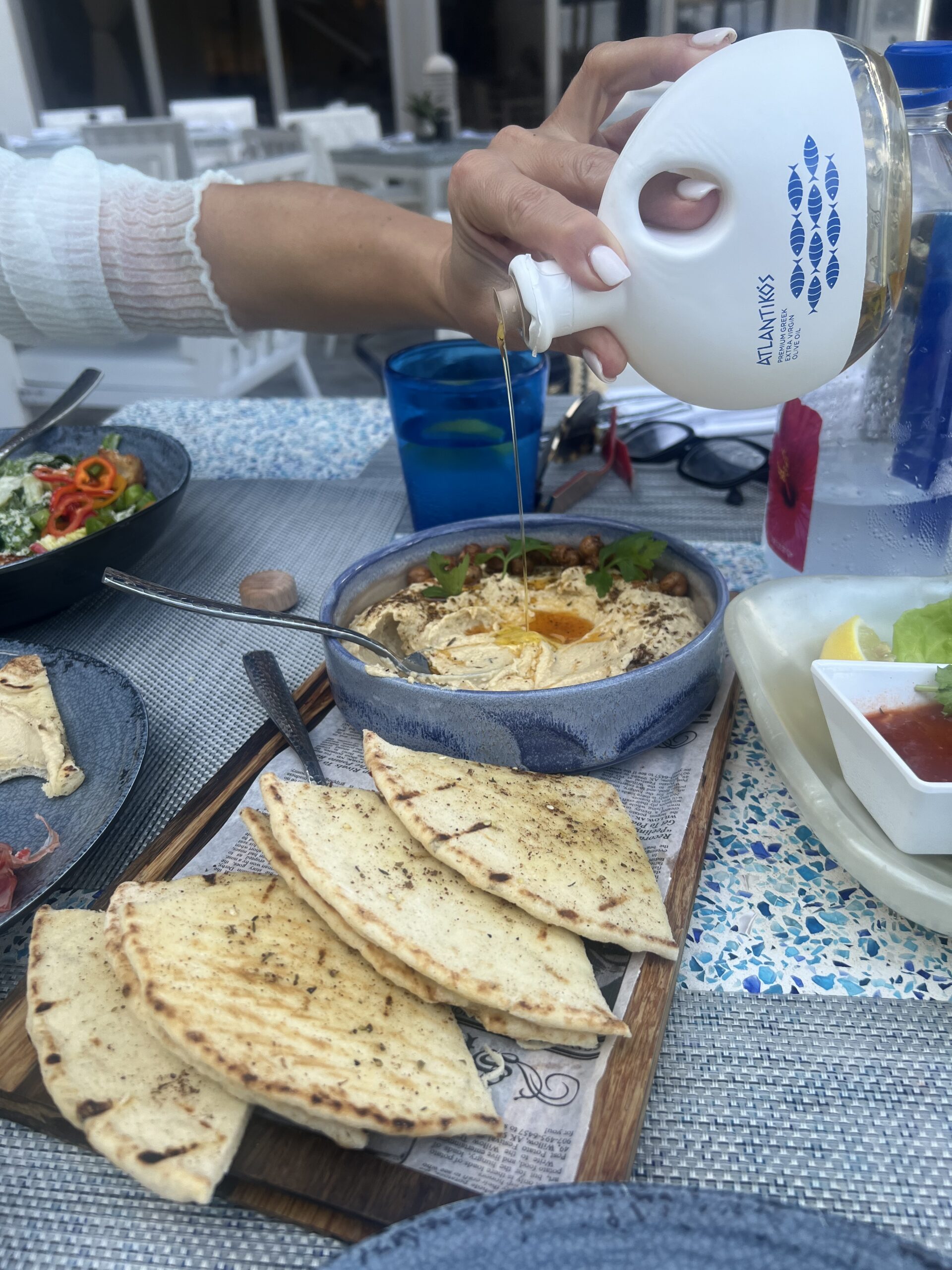 A person pouring sauce on some food