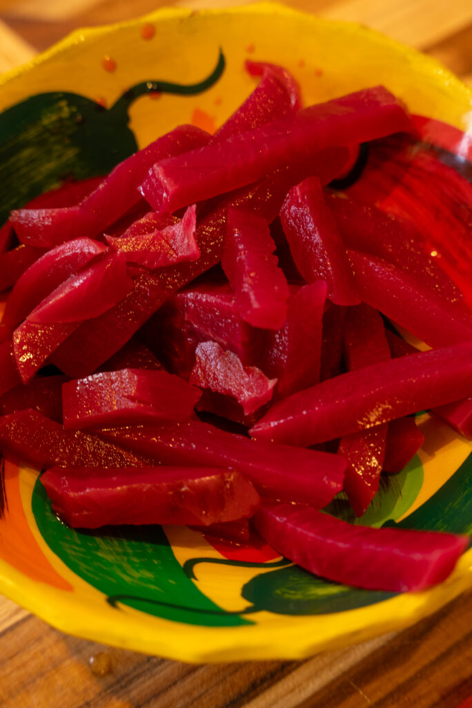 A bowl of red beets on a colorful plate.