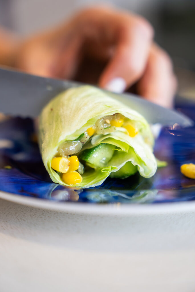 A table topped with avocados, cucumbers and other vegetables.