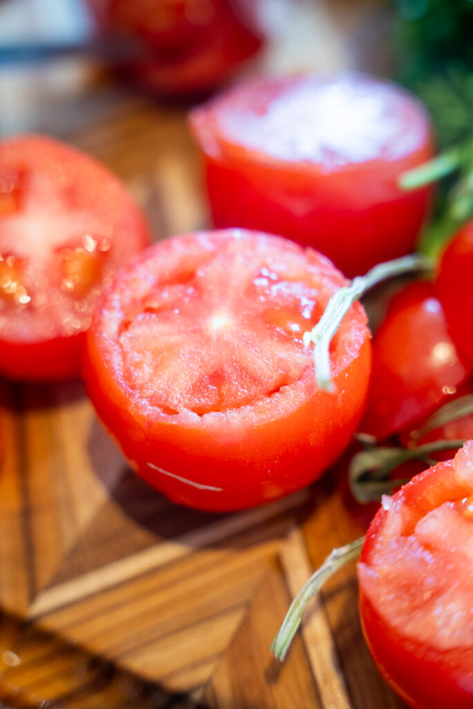 A cutting board with tomatoes, celery and herbs.