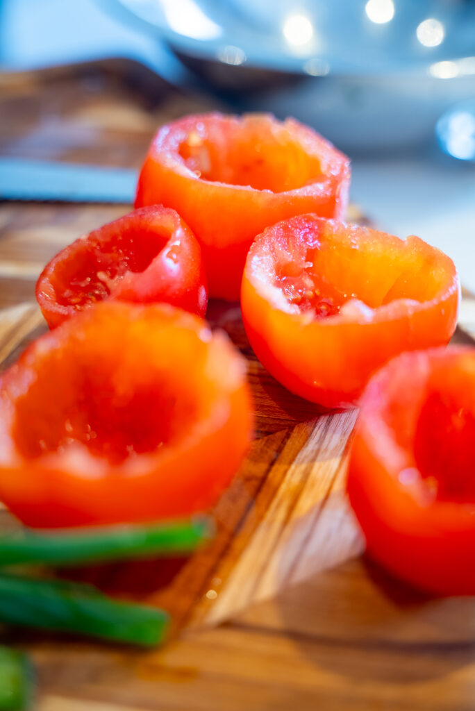 A cutting board with tomatoes, celery and herbs.