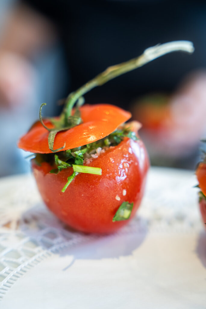 A cutting board with tomatoes, celery and herbs.