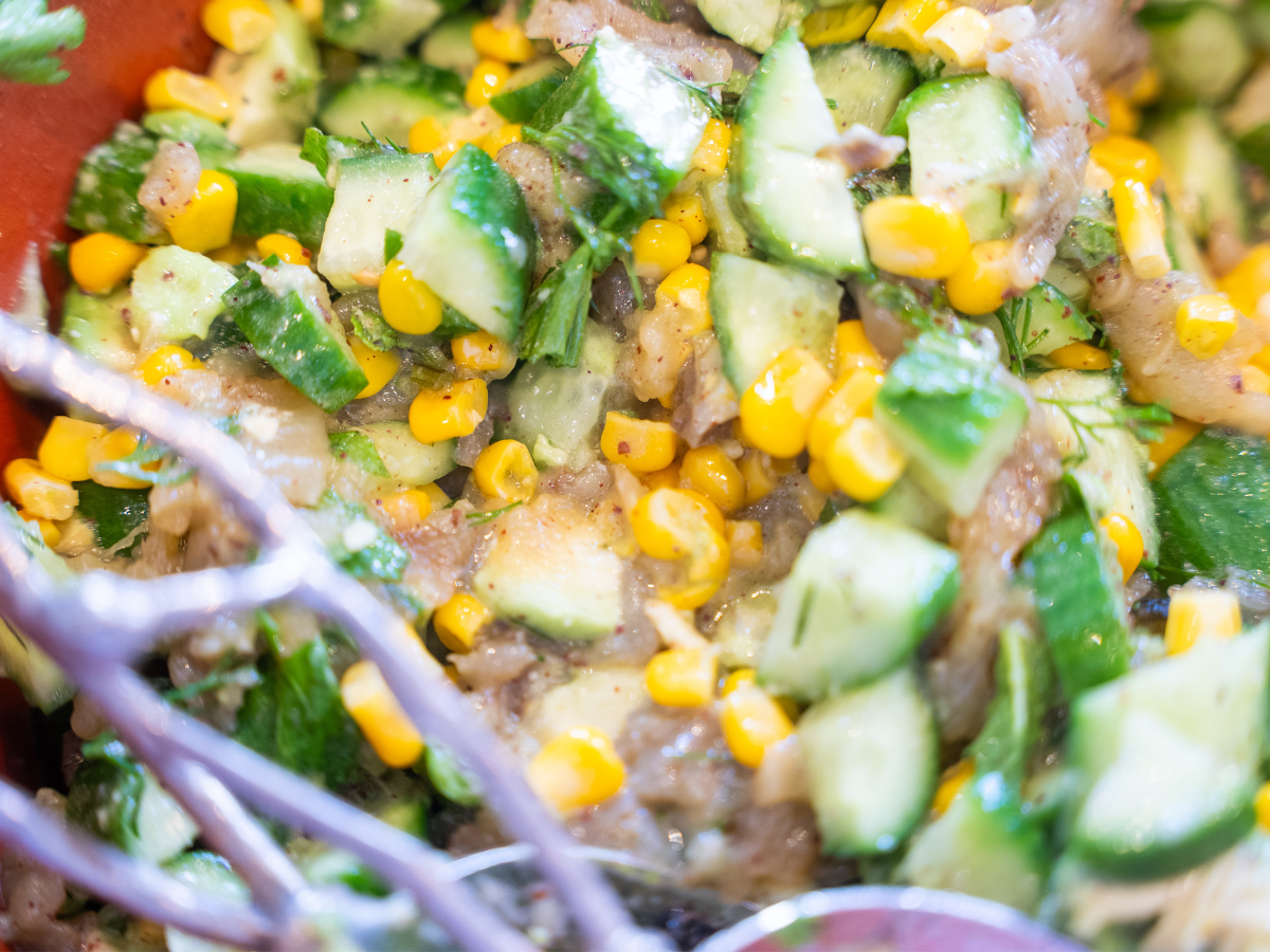 A close up of corn and cucumber salad