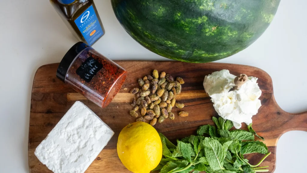 A wooden cutting board topped with nuts and cheese.