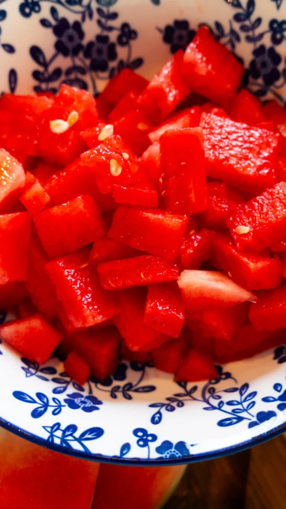 A watermelon, cheese and mint on the table.