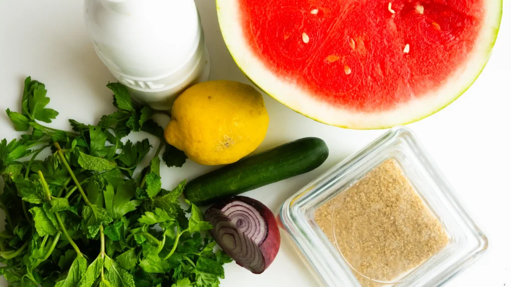 A table topped with lots of food and some water.