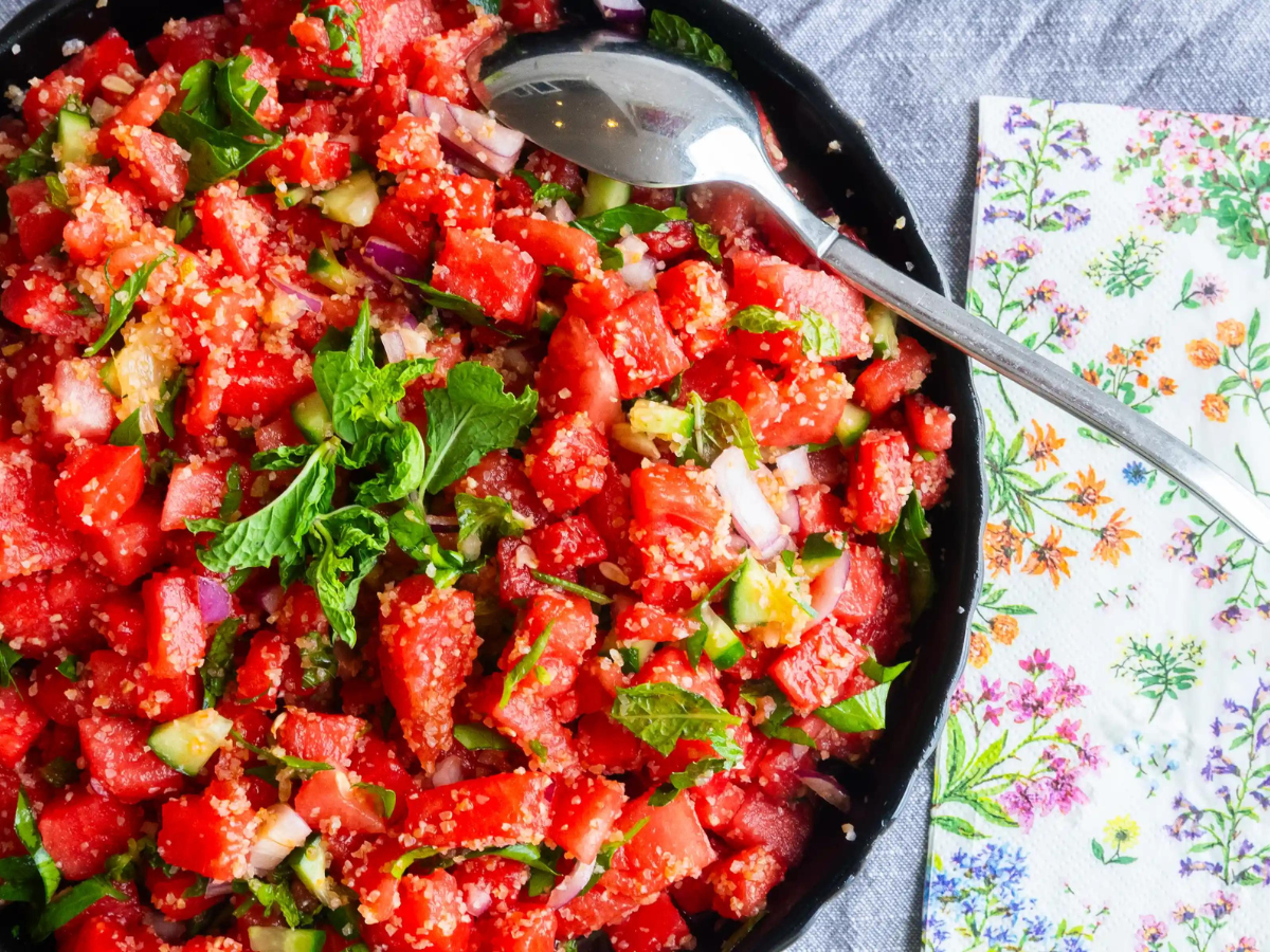 A bowl of salad with tomatoes and lettuce.