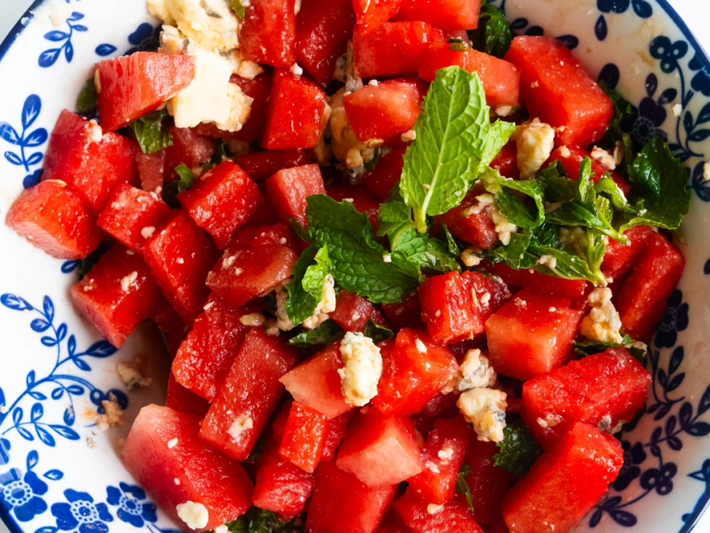 A plate of watermelon salad with feta cheese and mint.