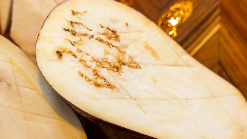 A woman is cutting cheese in the kitchen.