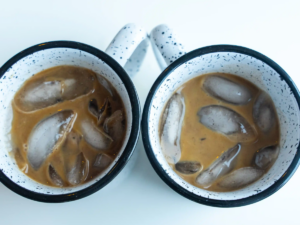 Two cups of coffee with ice in them.