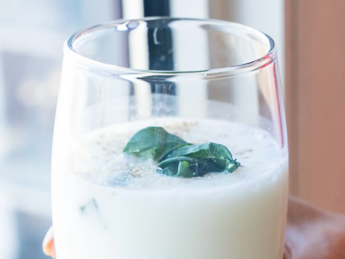 A glass of milk with some leaves on top