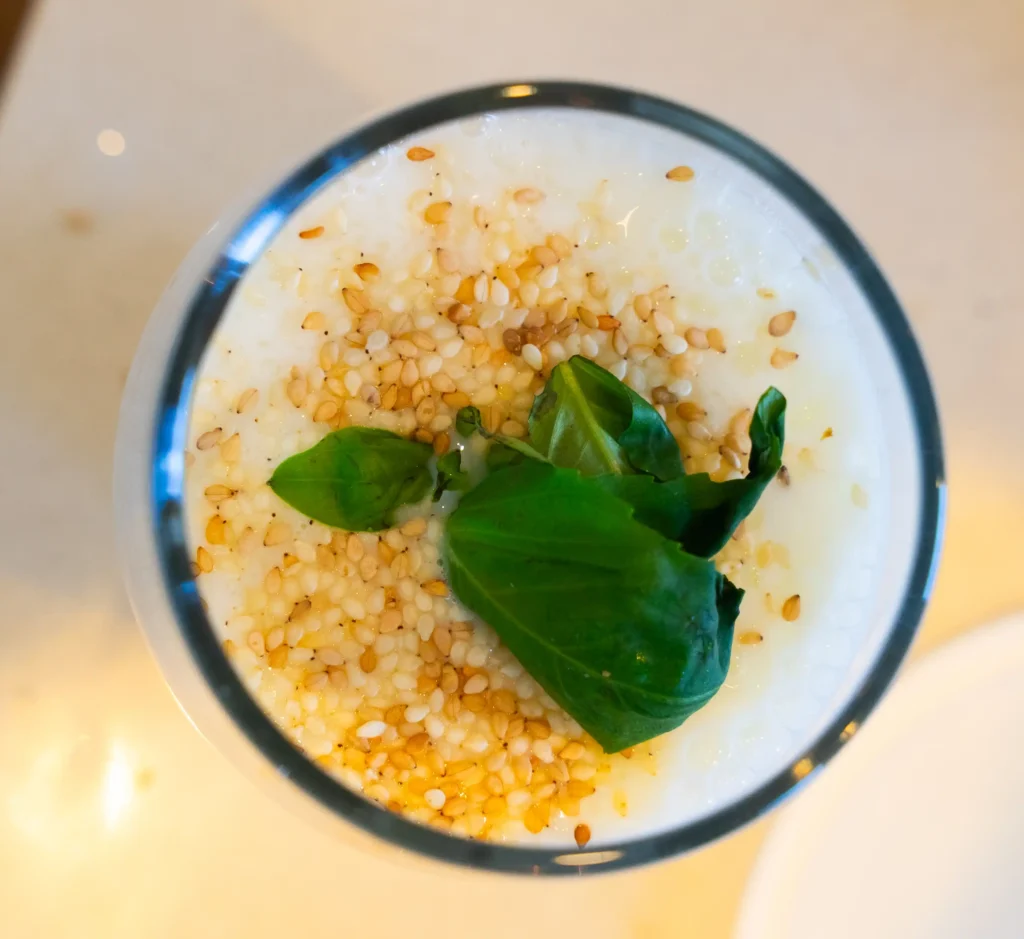 A yogurt container and lemon sitting on top of a table.